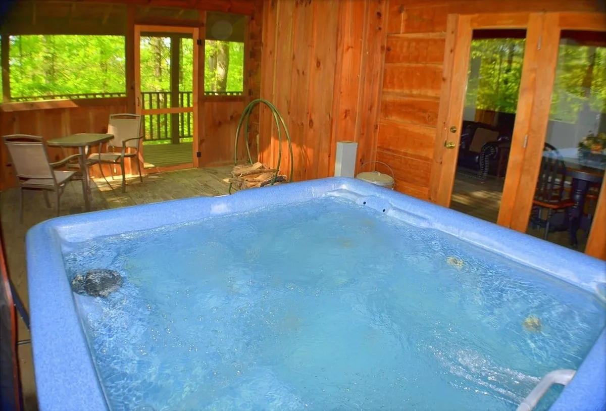 This interior shot features a hot tub set against warm wooden walls, with a view that connects directly to the outdoors. The inviting hot tub is the focal point, suggesting opportunities for relaxation, stargazing, or enjoying a drink while soaking. Natural light and an open layout blur the line between indoor comfort and the outdoor environment.